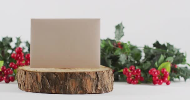 浆果和叶子圣诞装饰的视频用空白白色卡片在圆木上 白色背景 圣诞节 传统和庆祝概念 — 图库视频影像