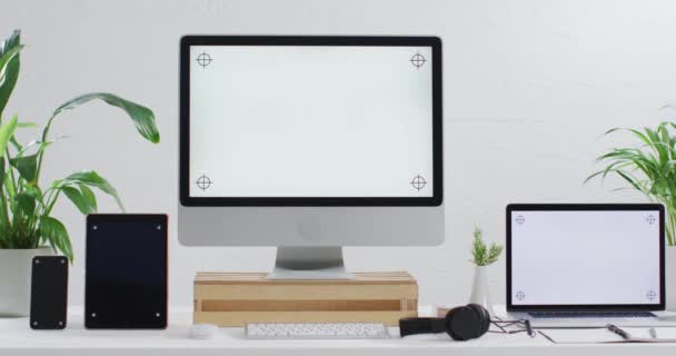 オフィスのコピースペースと木製のテーブルの上にノートパソコン スマートフォン タブレットやコンピュータのビデオ テクノロジービジネスワークステーションホームオフィスコンセプト — ストック動画