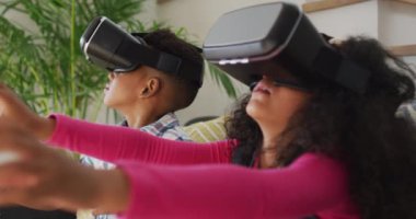 Siyah kulaklık takıp eğlenen Afro-Amerikan kardeşler. çocukluk, eğlence ve keşif teknolojiyi evde kullanmak.