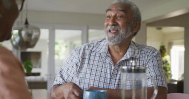 Kahveli mutlu Afro-Amerikan kıdemli bir adamın kadın ortağıyla konuşması animasyonu. sağlıklı, aktif emeklilik yaşam tarzı evde.