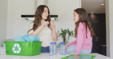 Kafkasyalı mutlu anne ve kız geri dönüşüm hakkında konuşuyor. Aile zamanı, boş zaman ve evde kaliteli zaman geçirme.