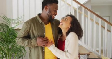 Kucaklaşan ve kameraya bakan mutlu Amerikalı çift. Aile zamanı, evde birlikte eğlenmek..