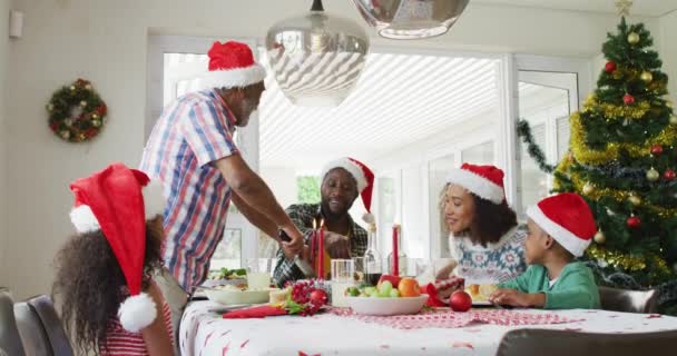 快乐的非洲裔美国多代家庭戴着圣诞礼帽 庆祝节日大餐 全家在家里共度圣诞节和共度佳节 — 图库视频影像