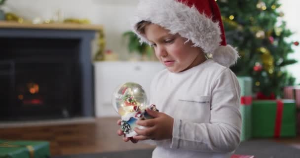 Chico Caucásico Sorprendido Usando Sombrero Santa Jugando Con Bola Nieve — Vídeos de Stock