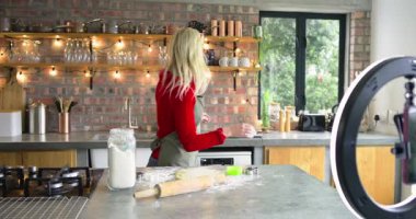 Saç bandı ve önlük takan kadın, yıldız kesicinin hamuru yuvarladığını ve kurabiye kestiğini gösteriyor. Pişirme, hamur işi, aşçılık, festival, tatil, mevsimlik, ev yemeği