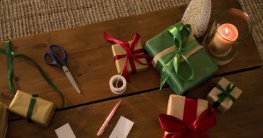 Masanın üzerinde soldan sağa tarama yapmaya başla, altın sarısı hediyeler ve paketleme aletleri ortaya çıkar. Şenlikli, rahat, zarif, mevsimlik, el yapımı, sıcak, samimi