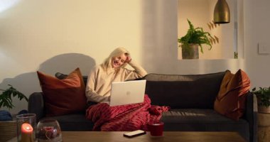 Kadın güneş ışığının aktığını fark ediyor, evde dizüstü bilgisayarda yazmaya başlamadan önce duraklıyor. Konfor, konfor, rahatlama, çalışma alanı, evcil, yaşam tarzı, huzur