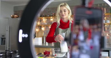 Şeker kavanozu toplayan yetişkin beyaz kadın mutfak adasında malzemelerini hamura çeviriyor. Pişirme, pişirme, mutfak, mutfak gereçleri, yerli, yaşam tarzı, modern