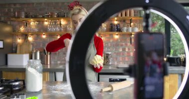 Akıllı telefon kayıtları kadın aşçı mutfağında noel pastası için hamur serpme ununu gösteriyor. Pişirme, pişirme, aşçılık, kutlama, şenlik, modern