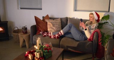 Kanepeye yaslanmış bir kadın. İnternetten kredi kartı alıyor, fotokopi çekiyor. Şenlikli, rahat, rahat, tatil, sıcak, evcil, yaşam tarzı