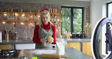 Telefon sinyalini fark ettim, önlük giymiş bir kadın una uzanıyor, yoğuruyor, mutfakta kek için hamur yoğuruyor. Pişirme, aşçılık, kırsal, şenlik, yaşam tarzı, öğretici, modern çiftlik evi