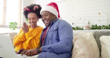 Noel Baba şapkalı, şeker kamışı bantlı çeşitli çiftler kanepeye dizüstü bilgisayar açıp bayram sohbeti yapıyorlar. Şenlik, kutlama, neşe, birliktelik, sıcaklık, ev, mevsim