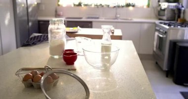 Ekranda yumurtaları elek ile kasenin yanına yerleştiriyor, kamera geri çekiliyor ve güneş ışığıyla aydınlanan mutfak ortaya çıkıyor. Fırın, yerli, minimalist, yaşam tarzı, aşçılık, aydınlık, rahat