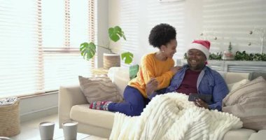 Çeşitli çiftler hediyelerin gelişine tepki gösteriyorlar, yeşil kutu yerleştiriyorlar ve evdeki kanepede kurdeleyi çözüyorlar. Romantik, kutlama, samimi, neşeli, samimi, neşeli, evimsi