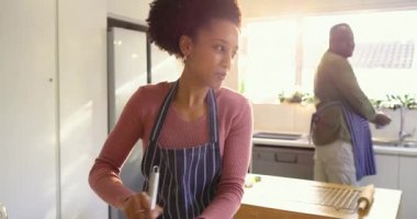 Güneş ışığı, mutfakta hamuru karıştıran Afrika kökenli Amerikalı çift, bulaşık yıkayan adam kaçıran kadın. Yemek, ev, ev, yaşam tarzı, modern, neşeli, işbirliği