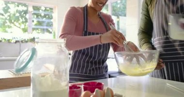 Mutfak adasında çeşitli çiftler yemek pişirmek için çırpılmış yumurta hamuru çırpıyorlar. Yemek pişirme, takım çalışması, yerli, canlı, yaşam tarzı, aşçı, neşeli