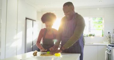 Mutfak adasında rozetli çeşitli çiftler kurabiye damgalıyor ve birlikte gülüyorlar. Romantizm, takım çalışması, yerli, aşçı, yaşam tarzı, işçilik, neşe