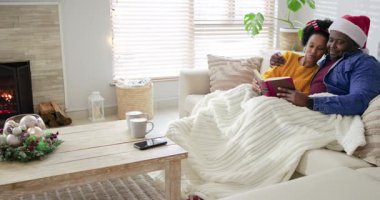 Kırmızı kitabın açılışında, çeşitli çiftler beyaz battaniyeye eğilip şöminenin yanında fotokopi çekiyorlar. Sıcaklık, samimiyet, rahatlama, şömine, mevsimlik, beslenme, sıcaklık.