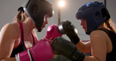 Eldivenleri tokuşturduktan sonra beyaz kadın boksörler boks salonunda antrenman yapmak için yumruk ve kanca değiş tokuşu yaptılar. Atletik, güç, rekabet, eğitim, spor, güçlü, dinamik