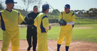 Sopa kaldırma, hakem, kale levhası istifleme eldivenlerinde sarı forma giyen 3 erkek oyuncu. Sporcular, takım çalışması, kutlama, rekabet, açık hava, sportmenlik, dostluk