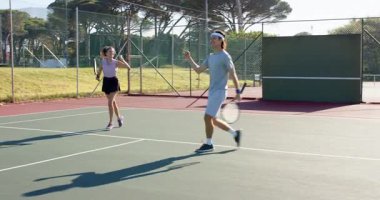 Bir sonraki talim için mahkemeye girmeden önce Asyalı bir adamın bayan takım arkadaşıyla oynaması. Atletik, takım çalışması, açık hava, canlı, rekabetçi, fitness, boş zaman