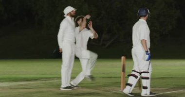 Deri top kapmak, Afrika kökenli erkek bovling oyuncusu serbest bırakmak, kütüklere vurmak ve geceleri tezahürat yapmak. Kriket, gece, spor, atletizm, stadyum, takım, yarışma