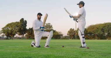 Diz çöküp sopayı alan, çeşitli erkek stajyerler kriket sahasında hızlanmak için yarasa atışlarını senkronize ediyorlar. Spor, antrenman, takım çalışması, açık hava, fitness, koordinasyon, odaklanma