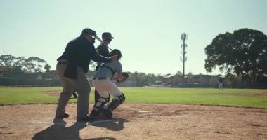 Vahşi sahaya tepki veren erkek oyuncular, serbest topu kovalıyor ve beyzbol sahasında kale levhasını koruyorlar. Atletizm, sportmenlik, rekabet, hareket, açık hava, takım, çeviklik