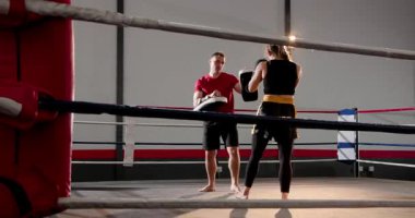 Boks ringine girmek ve eldiven kaldırmak, erkek antrenör ve kadın stajyer, zamanlama alıştırması yapıyor. Eğitim, spor, hareket, güç, kararlılık, rekabet, atletizm