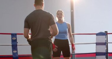 Dişi boksör ve erkek antrenör ringe kırmızı şalter ve siyah eldiven takarak ev işlerini hazırlıyorlar. Atletizm, eğitim, disiplin, motivasyon, rekabet, fitness, kararlılık