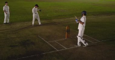 Çekirge kalesinde kaybolan Hintli vurucu ışıkların altında kale yakalıyor. Spor, rekabet, atletizm, oyun, aksiyon, gece vakti, stadyum