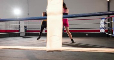 Pembe boksör, sol yumruk ve siyah giysili rakibi antreman sırasında ringde eldivenle blokluyor. Sporcular, fitness, mücadele, eğitim, spor giyim, motivasyon, güç