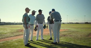 Kıdemli koç beyzbol tutuşu gösteriyor, farklı erkek oyuncular sahada koşarken alkışlıyor. Koçluk, antrenman, takım çalışması, fiziksel aktivite, açık hava, atletik, motivasyon