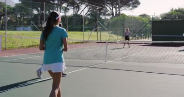 Asyalı erkek ve kadın rakip atışlardan sonra internette voleybol oynuyorlar, tenis kortunda bir sonraki servisi tartışıyorlar. Atletik, takım çalışması, açık hava, canlı, rekabetçi, dinamik, sportmenlik