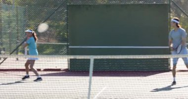 Rakipleri tebrik etmek için koşana kadar tenis kortunda raket dağıtan çeşitli ikili. Atletizm, takım çalışması, rekabetçi, sportmenlik, açık hava, zafer, aktif