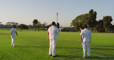 Atış talimine başlıyoruz. Farklı erkek takımlar, dönen bovling ve park alanında vuruş yapıyor. Atletizm, takım çalışması, sportmenlik, açık hava, aktivite, rekabet, doğal