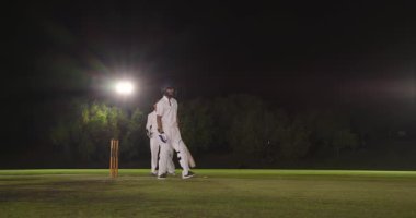 Geceleyin çeşitli erkek takımları topa vuruyor, topa vurduğu için tutucu kaleyi kırıyor. Spor, stadyum, yarışma, atletik, turnuva, takım, aksiyon