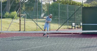 Top fırlatmak farklı arkadaşların kırmızı kil sahada hizmet edip el sıkışmasına neden olur. Atletik, rekabetçi, dinamik, açık hava, enerjik, sportmence, takım çalışması