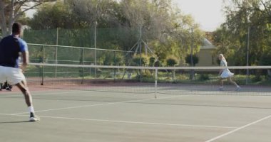 Voleyboldan sonra çeşitli tenis partnerleri açık alanda koç izlerken voleybol oynuyorlar. Atletik, antrenman, spor, rekabetçi, dinamik, açık hava, koçluk