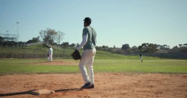 Afrika kökenli Amerikalı oyuncu sahadan çıktıktan sonra sahaya çıkıp eldiven takmayı bekliyor. Atletik, takım çalışması, sportmenlik, açık hava, canlı, rekabetçi, antrenman