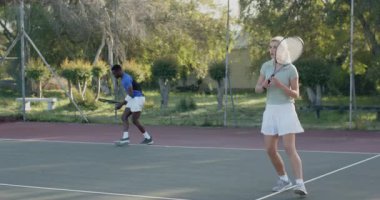 Çeşitli erkek ve kadın rakipler sert kortta el altından, ters vuruş yaparak miting yapıyorlar. Atletik, rekabetçi, canlı, aksiyon, açık hava, odaklanma, hareket