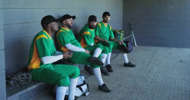 Akıllı telefon, çeşitli erkek takım arkadaşları yedek kulübesinde toplanıyor. Yarasalar ve eldivenlerle. Sportmenlik, dostluk, takım çalışması, atletizm, boş zaman, gündelik, açık hava