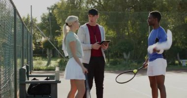 Tablet verilerini gözden geçirmek, çeşitli tenis hocaları ve öğrencilerin ısınması, el sıkışması, sahadan uzaklaşması. Atletik, takım çalışması, eğitim, strateji, fitness, açık hava, motivasyon