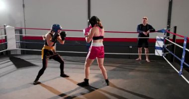 Koç ringe giriyor, bayan stajyerleri idman yapmaya teşvik ediyor ve savunma için gardiyanların boyunu gösteriyor. Martialart, antrenman, spor, fitness, disiplin, spor, motivasyon