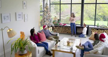 Evde tatil hikayesini paylaşan olgun bir kadın. Gümüş Noel ağacı ve penceresi sunuyor. Kopya alanı. Şenlik, aile, kutlama, sıcaklık, ev, konfor, neşe