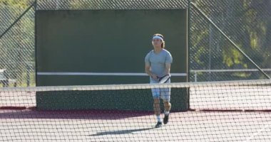 Tenis partnerleri topa vuruyor, duvara vuruyor, beşlik çakıyor ve kortta pozisyon değiştiriyor. Atletik, takım çalışması, hareket, açık hava, sportmenlik, canlı, rekabet