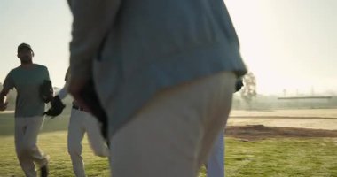 Sabah güneşi motivasyon koçu çeşitli takım arkadaşları sahada koşuyor ve sopayı sallıyor. Atletik, takım çalışması, sportmenlik, fiziksel aktivite, açık hava, antrenman, canlı