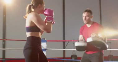 Koçla boks ringine girmek, kadın stajyer antrenman için odak yastıklarını tekmeliyor. Eğitim, fitness, martialarts, yetkilendirme, güç, kas, kararlılık