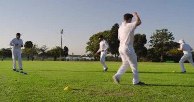 Dönüşümlü dönüşler, çeşitli erkek takım arkadaşları kriket sahasında kozalaklara koşuyor ayak egzersizleri yapıyorlar. Atletik, antrenman, çeviklik, spor, takım çalışması, açık hava, spor