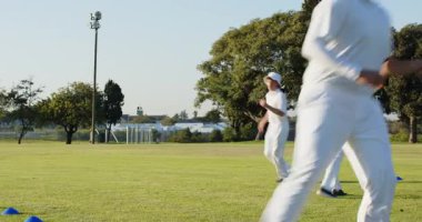 İşaretten sonra, çeşitli erkek ikili antrenman için sahada mavi koni etrafında diz üstü basamaklar yapıyor. Sporcular, antrenman, çeviklik, açık hava, spor, spor